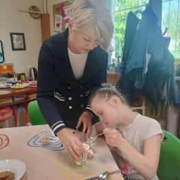 Pani dyrektor wspólnie z Patrycją przygotowują deser owocowy.