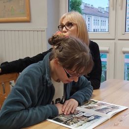 Dziewczynka czyta komiks o II wojnie światowej. 