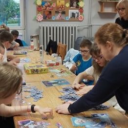 Chłopcy i dziewczyki układają puzzle. 
