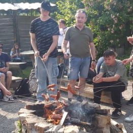 dzieci i wychowawcy smażą kiełbaski