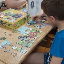 Chłopiec układa puzzle. 