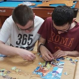 Chłopcy układają puzzle. 