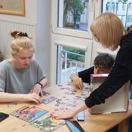 Chłpiec i dzieczynka układa puzzle.
