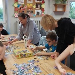Chłopcy i dziewczyki układają puzzle. 