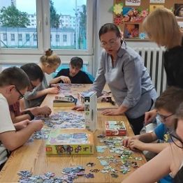 Chłopcy i dziewczyki układają puzzle. 