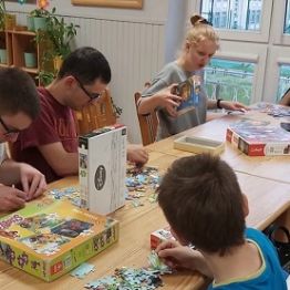 Chłopcy i dziewczyki układają puzzle. 