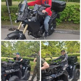 Wychowankowie pozują do zdjęcia siedząc w podjazdach wojskowych.