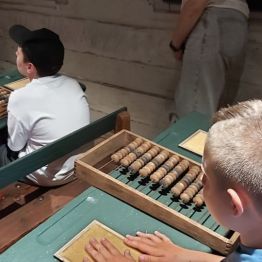 dzieci siedzą w ławkach szkolnych, dawniej szkoła