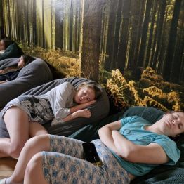 Podopieczne w rozluźnieniu słuchają muzyki relaksacyjnej.