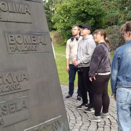 Wychowankowie czytający napisy na pomniku.