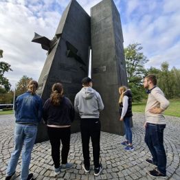 Wychowankowie czytający napisy na pomniku.