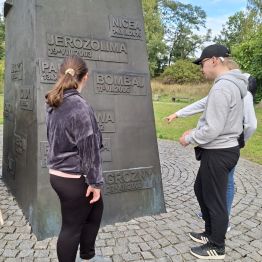 Dxuewczynka patrzy na napisy obok niej chłopiec.