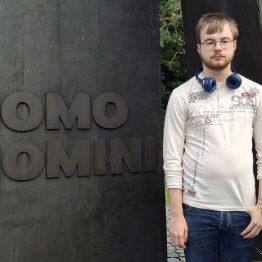 Wychowanek przy napisie HOMO HOMINI.