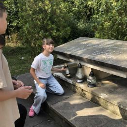 Uczennica klasy 3 a zapala znicz pod pomnikiem