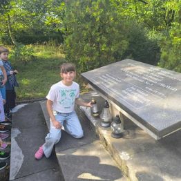Uczennica klasy 3 a zapala znicz pod pomnikiem
