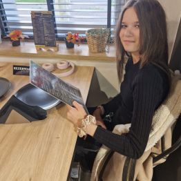 Wychowanka przegląda menu pizzerii 