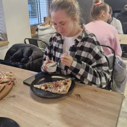 Wychowanka nakłada sos na pizze 