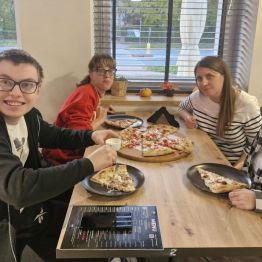 Wychowawca z wychowankami pozuje do zdjęcia w pizzerii