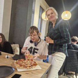 Wychowanek nakłada sobie kawałek pizzy 