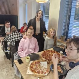 Wychowawca z wychowankami pozuje do zdjęcia w pizzerii 