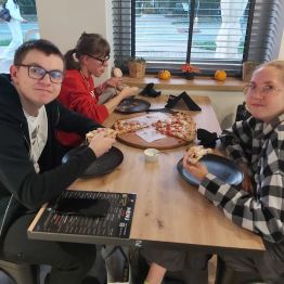 Wychowankowie częstują się pizzą