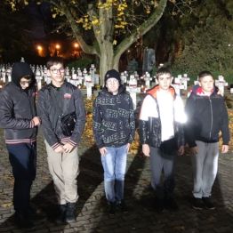 Chłopcy stoją przy grobach