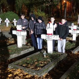 Chłopcy stoją przy grobach