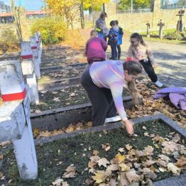 Uczniowie klas I-III porządkujący groby poległych podczas II wojny