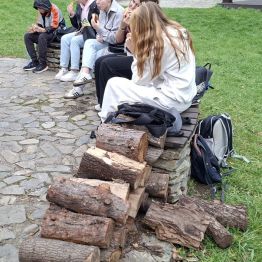 Konsumpcja kiełbasek przy ognisku.