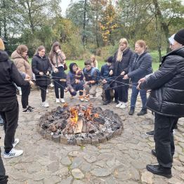 Wychowankowie i wychowawcy przy ognisku.