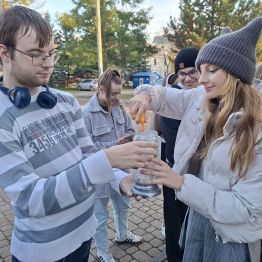 Wychowankowie zapalają znicz przed pomnikiem .
