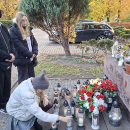 Dziewczynka zapalamy znicz pamięci.