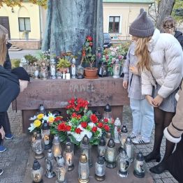 Wychowankowie czytający napisy pod pomnikiem.