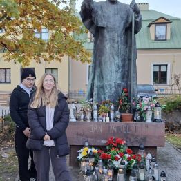 Chłopiec i dziewczynka przed pomnikiem.