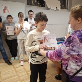 Wychowanek odbiera dyplom i nagrodę za udział w konkursie.