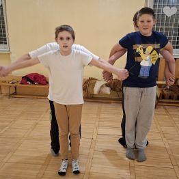 Wychowankowie trzymają się za dłonie i tworzą samolot.