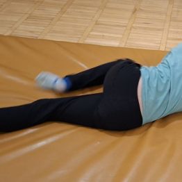 Wychowanek przesuwa się na brzuchu wzdłuż materaca.