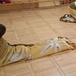 Chłopiec zwinięty w kocyk próbuje wstać.