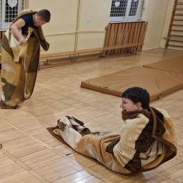 Wychowankowie zwinięci w kocyk próbują wstawać na nogi.