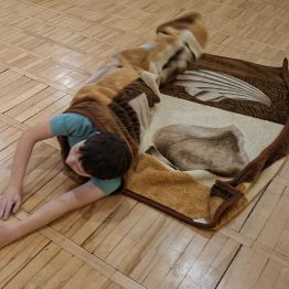 Wychowanek zwija się w kocyk i próbuje wstać.