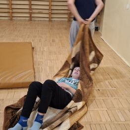 Wychowanek ciągnie na kocyku kolegę.