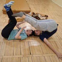 Wychowankowie próbują dotknąć się  tyłem palcami swoich stóp.