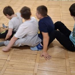 Wychowankowie tworzą wagoniki pociągowe i przesuwają się po podłodze.