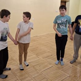 Chłopcy parami prowadzą tych uczestników, którzy mają zamknięte