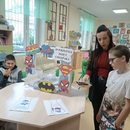 Wychowawczyni z chłopcami w trakcie słodkiego poczęstunku.