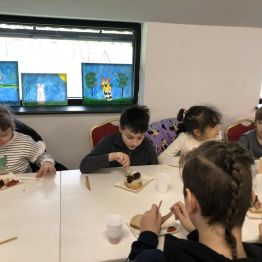 Uczniowie klas 1-3 podczas konsumowania kiełbasek z grilla.