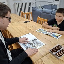 Chłpocy czytają komiksy o róznej tematyce.