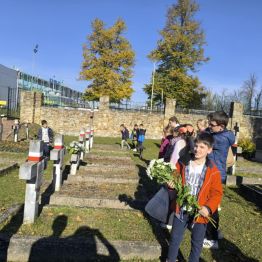 Uczniowie klas I-III zapalający znicze na mogiłach