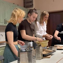 Uczestnicy zajęć nakładają produkty na ciasto.