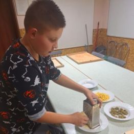 Wychowanek uciera żółty ser.